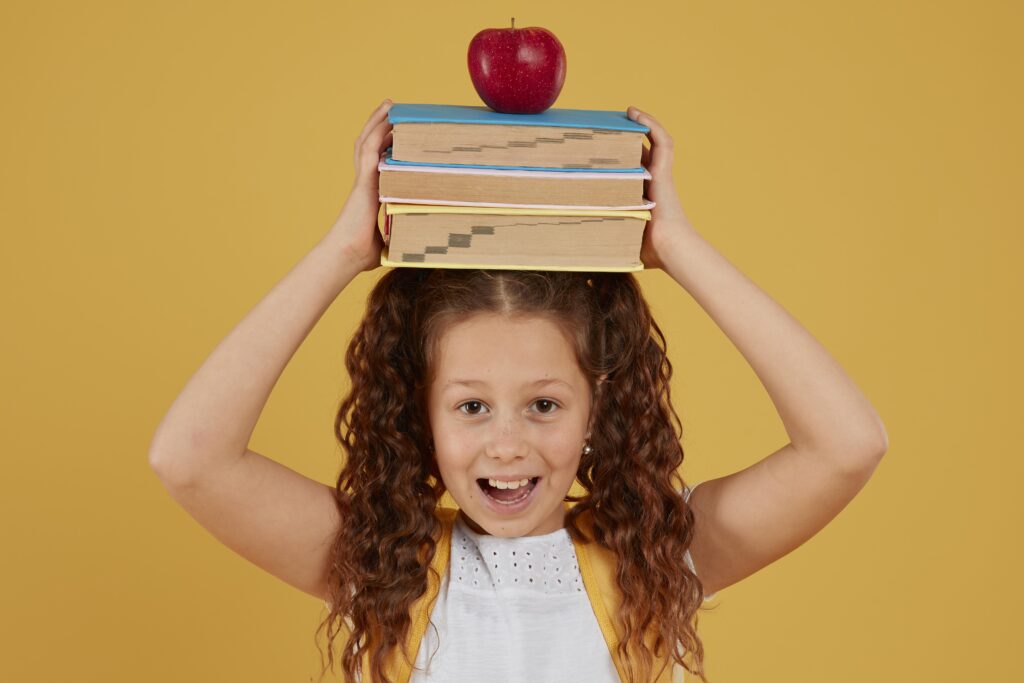 FOTOS ESCOLARESschool-girl-holding-books-apple-her-head